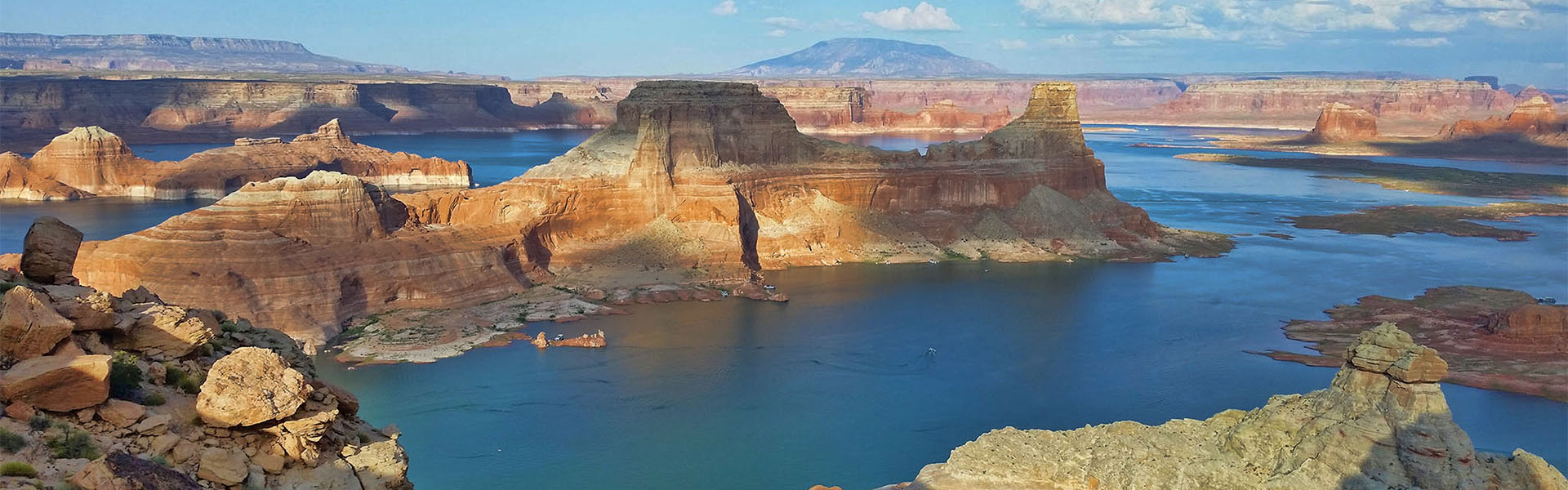 Blue Lake Powell waters between sunlit sandstone mesas
